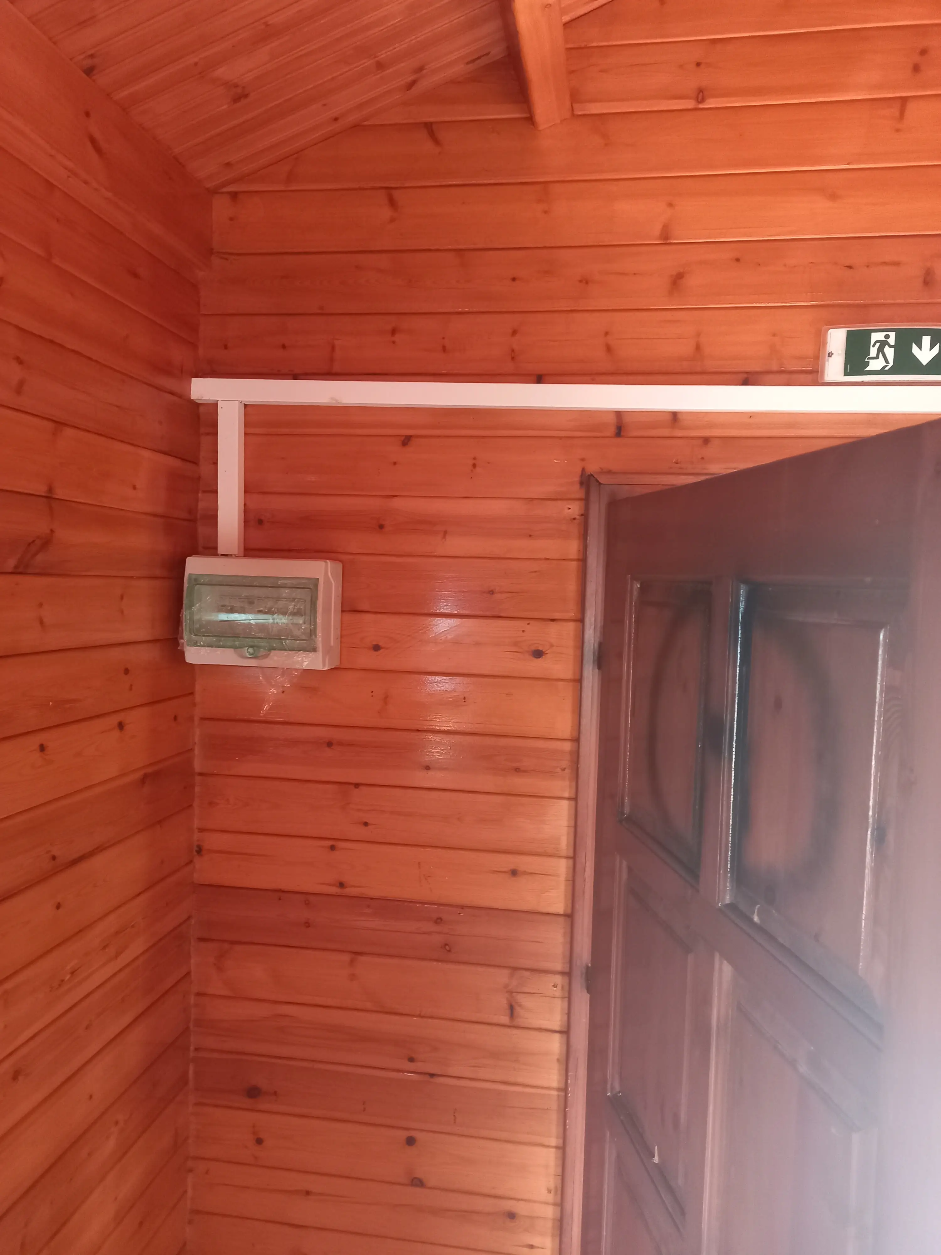 Απεικόνιση του ηλεκτρολογικού πίνακα σε ένα από τα δώδεκα ξήλινα σπιτάκια. Ο πίνακας βρίσκεται αριστερά της πόρτας.